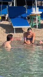 *PREMIUM-EXCLUSIVE* MUST CALL FOR PRICING BEFORE USAGE 
 - Bridgerton star Luke Newton packs on the PDA with Greek dancer girlfriend Antonia Roumelioti while she is sat on his lap on the beach in Sorrento