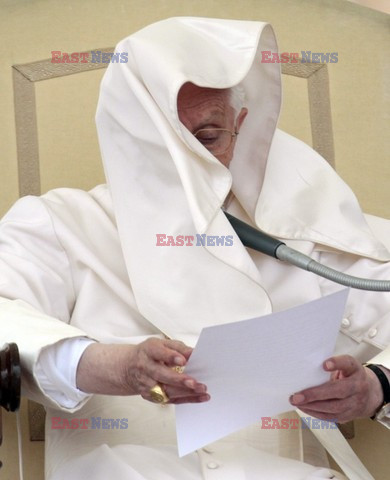 Pope mantle is blown by the wind as he reads his message during the weekly general audience