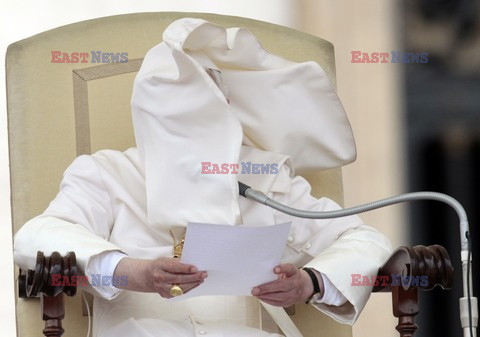 Pope mantle is blown by the wind as he reads his message during the weekly general audience