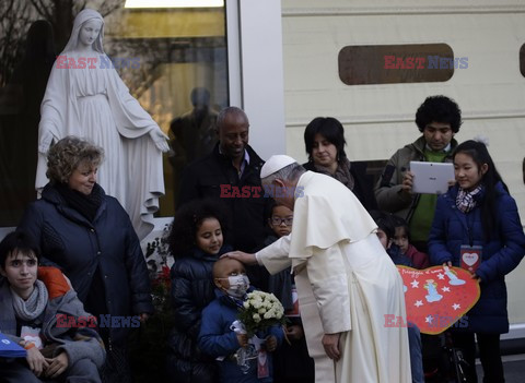 Pope Francis caresses a child as he arrives at the "Bambin Gesu'" children's hospital in Rome