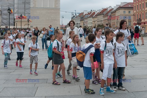 Dzieci i mlodzież oddają hołd pod pomnikiem Małego Powstańca