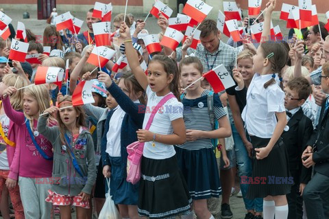 Dzieci i mlodzież oddają hołd pod pomnikiem Małego Powstańca