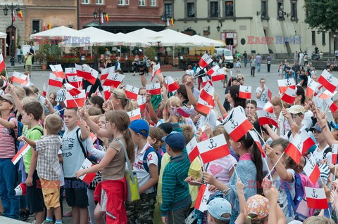 Dzieci i mlodzież oddają hołd pod pomnikiem Małego Powstańca