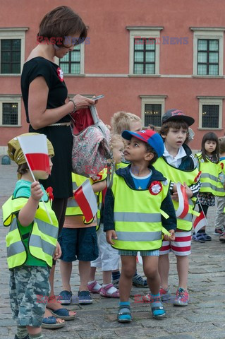 Dzieci i mlodzież oddają hołd pod pomnikiem Małego Powstańca