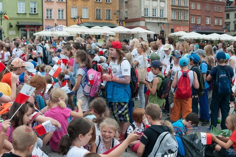 Dzieci i mlodzież oddają hołd pod pomnikiem Małego Powstańca