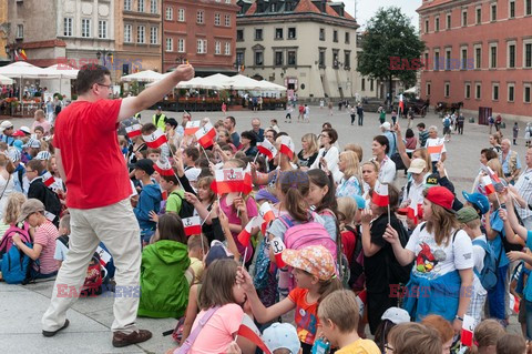 Dzieci i mlodzież oddają hołd pod pomnikiem Małego Powstańca