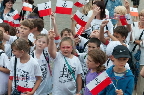 Dzieci i mlodzież oddają hołd pod pomnikiem Małego Powstańca