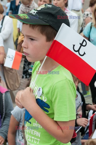 Dzieci i mlodzież oddają hołd pod pomnikiem Małego Powstańca