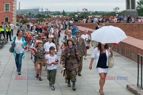 Dzieci i mlodzież oddają hołd pod pomnikiem Małego Powstańca