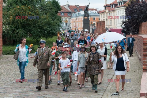 Dzieci i mlodzież oddają hołd pod pomnikiem Małego Powstańca