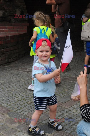 Dzieci i mlodzież oddają hołd pod pomnikiem Małego Powstańca