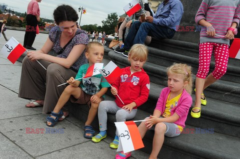 Dzieci i mlodzież oddają hołd pod pomnikiem Małego Powstańca