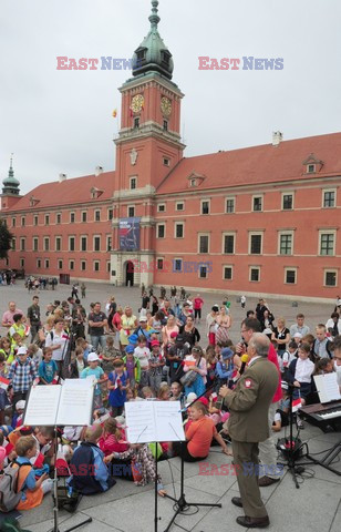 Dzieci i mlodzież oddają hołd pod pomnikiem Małego Powstańca