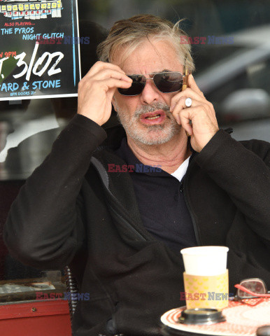 Chris Noth rozmawia przez telefon popijając kawę