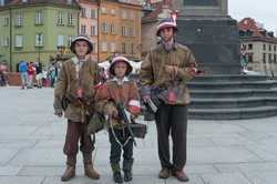 Dzieci i mlodzież oddają hołd pod pomnikiem Małego Powstańca