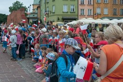 Dzieci i mlodzież oddają hołd pod pomnikiem Małego Powstańca