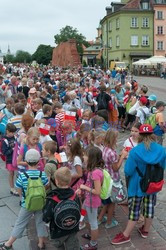 Dzieci i mlodzież oddają hołd pod pomnikiem Małego Powstańca