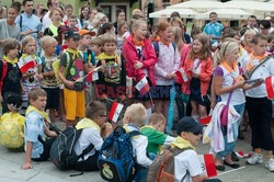 Dzieci i mlodzież oddają hołd pod pomnikiem Małego Powstańca