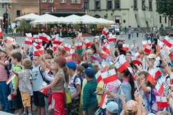 Dzieci i mlodzież oddają hołd pod pomnikiem Małego Powstańca