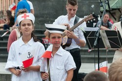 Dzieci i mlodzież oddają hołd pod pomnikiem Małego Powstańca