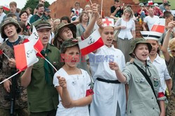 Dzieci i mlodzież oddają hołd pod pomnikiem Małego Powstańca