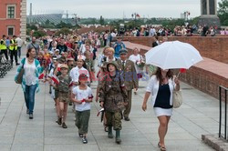 Dzieci i mlodzież oddają hołd pod pomnikiem Małego Powstańca