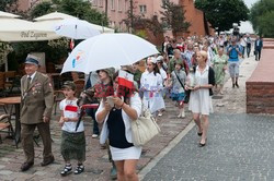 Dzieci i mlodzież oddają hołd pod pomnikiem Małego Powstańca