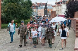 Dzieci i mlodzież oddają hołd pod pomnikiem Małego Powstańca