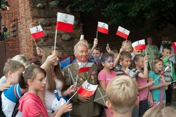 Dzieci i mlodzież oddają hołd pod pomnikiem Małego Powstańca