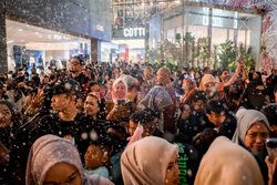 Ludzie bawią się w sztuczym śniegu w Kuala Lumpur